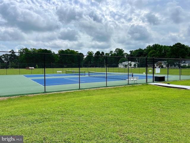 view of tennis court with a yard