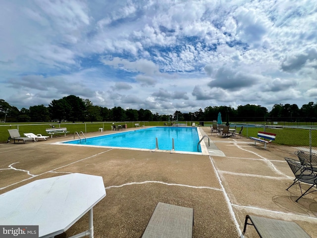 view of pool with a yard and a patio