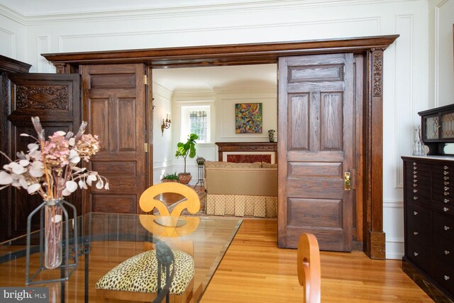 dining room with light wood-type flooring and crown molding