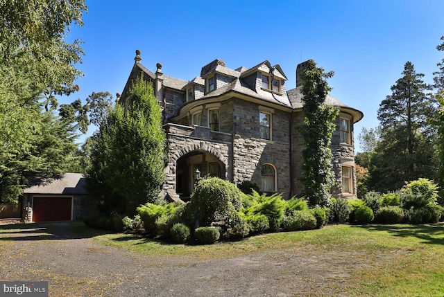 view of property exterior with a balcony, a yard, and a garage