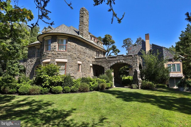 rear view of house featuring a yard