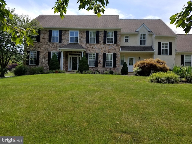 view of front of property with stone siding, stucco siding, and a front lawn