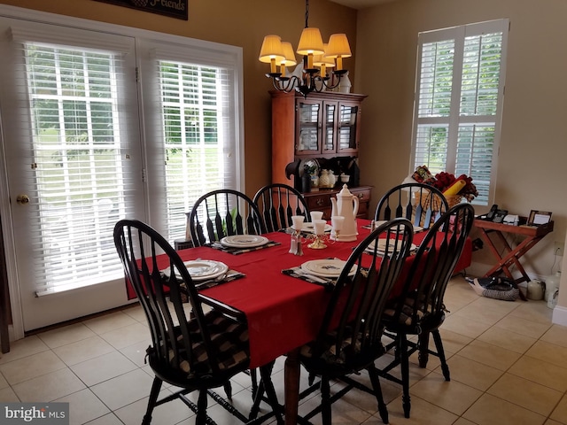 dining space featuring light tile patterned flooring, plenty of natural light, and a notable chandelier