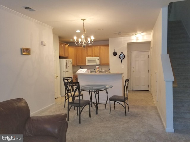 kitchen with light brown cabinetry, an inviting chandelier, white appliances, light colored carpet, and a breakfast bar