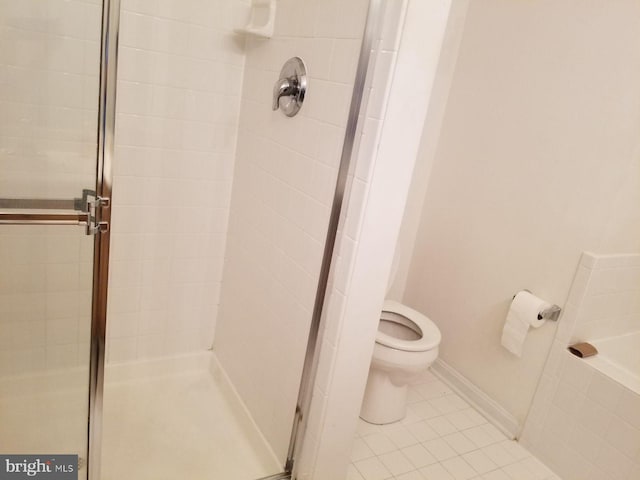 bathroom with toilet, tile patterned floors, and a shower with door