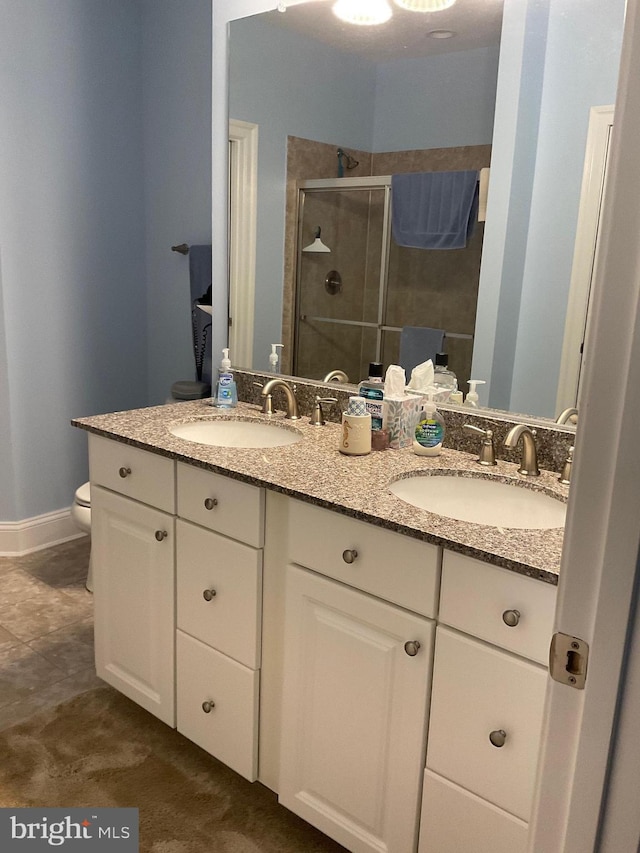 bathroom featuring toilet, a shower with door, and vanity