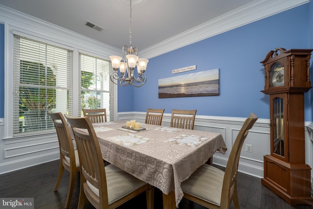 dining area featuring visible vents, a wainscoted wall, ornamental molding, wood finished floors, and an inviting chandelier