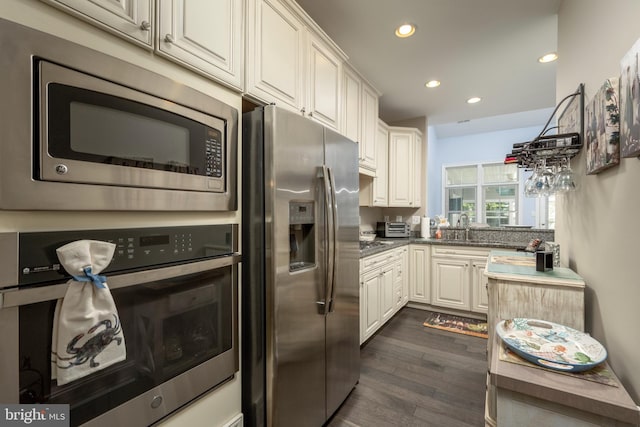 kitchen featuring dark wood-type flooring, a toaster, recessed lighting, stainless steel appliances, and a sink