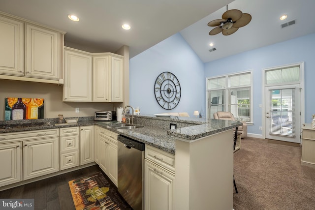 kitchen with visible vents, a sink, dark stone counters, appliances with stainless steel finishes, and a peninsula