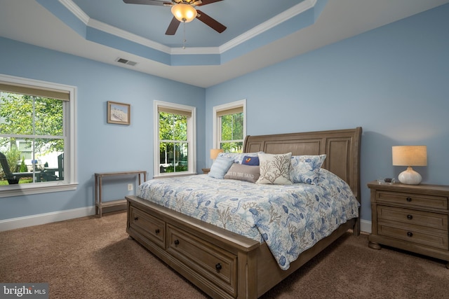 carpeted bedroom with visible vents, a raised ceiling, baseboards, and ornamental molding