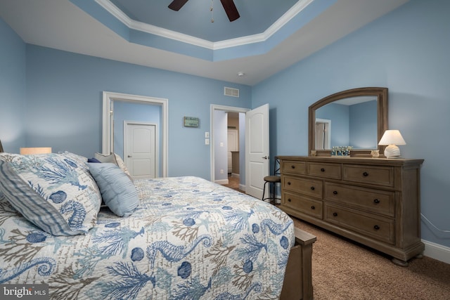 carpeted bedroom featuring visible vents, ceiling fan, baseboards, a tray ceiling, and ornamental molding