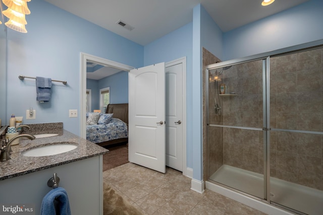 ensuite bathroom featuring visible vents, a shower stall, double vanity, ensuite bath, and a sink