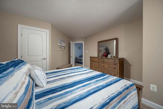 carpeted bedroom with visible vents and baseboards