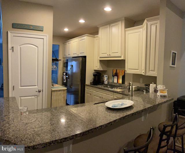 kitchen featuring kitchen peninsula, appliances with stainless steel finishes, and white cabinetry