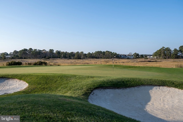 surrounding community featuring view of golf course and a lawn