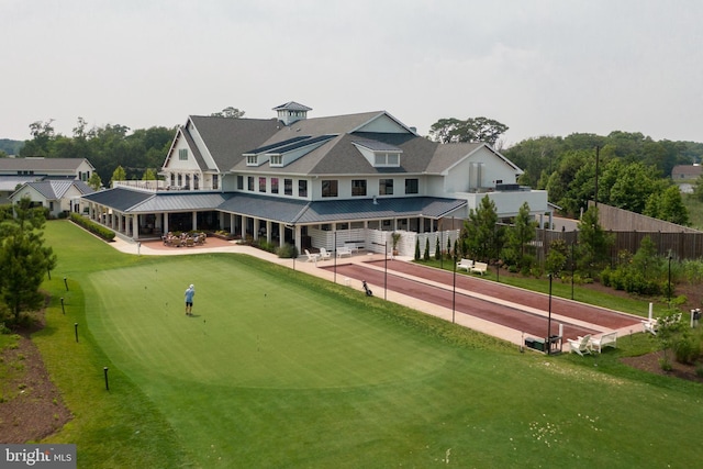 view of community with a patio, fence, and a lawn