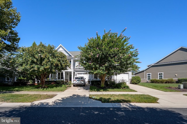 obstructed view of property featuring concrete driveway, a garage, and a front lawn