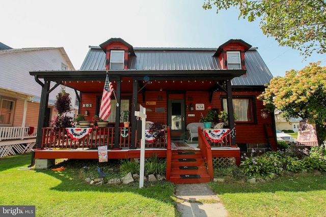 view of front of home featuring metal roof, a front lawn, and a porch