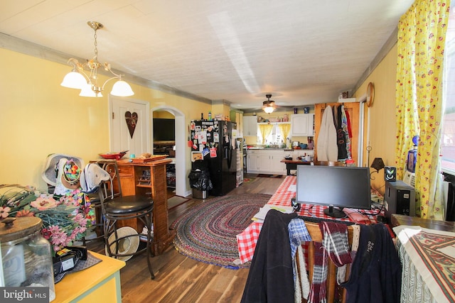 interior space featuring wood-type flooring and ceiling fan with notable chandelier