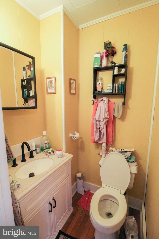 bathroom with vanity, hardwood / wood-style floors, crown molding, and toilet