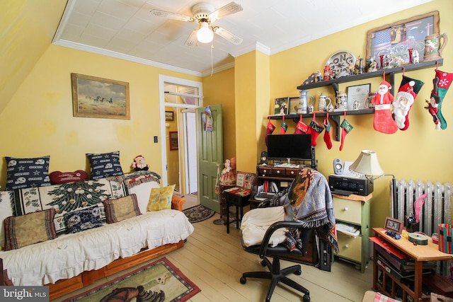 office area featuring hardwood / wood-style flooring, ceiling fan, radiator heating unit, and crown molding