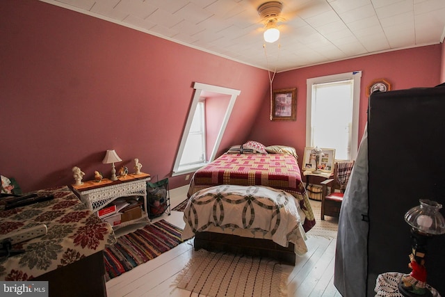 bedroom with crown molding, hardwood / wood-style floors, and ceiling fan