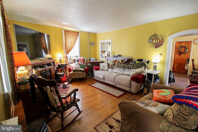 living room featuring cooling unit, ornamental molding, and wood-type flooring