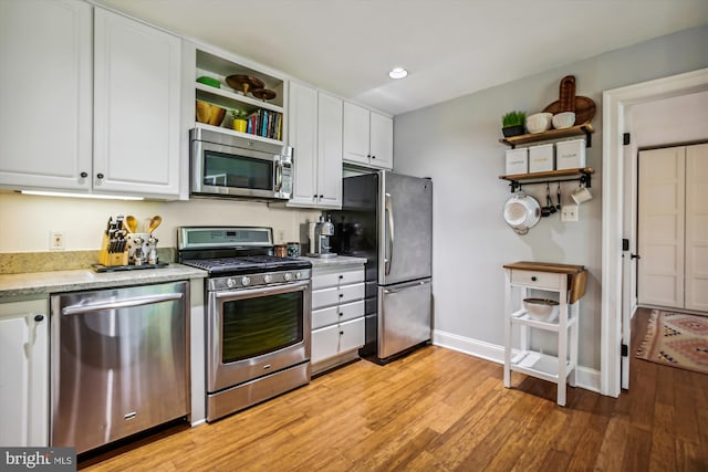 kitchen featuring light wood-type flooring, white cabinets, and appliances with stainless steel finishes