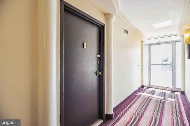 hallway with dark colored carpet and baseboards