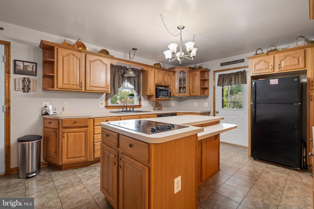 kitchen with hanging light fixtures, a center island, a notable chandelier, sink, and black appliances