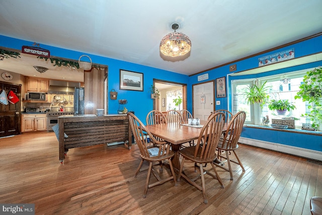 dining space with plenty of natural light, light hardwood / wood-style flooring, and a baseboard radiator