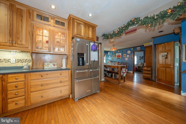 kitchen with light wood-type flooring, decorative backsplash, and high quality fridge