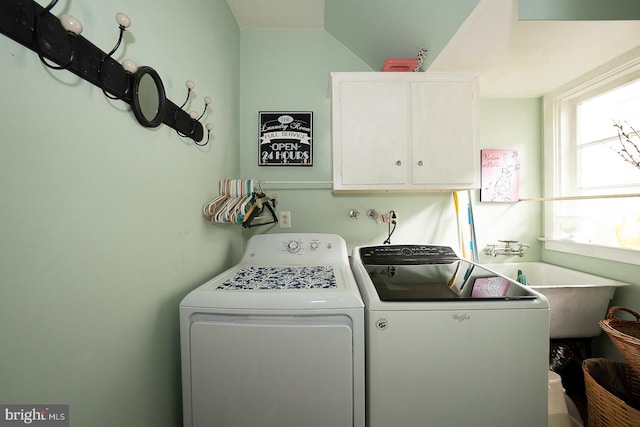 clothes washing area featuring independent washer and dryer, cabinets, and sink