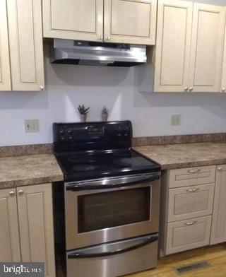 kitchen featuring stainless steel range with electric stovetop and light wood-type flooring