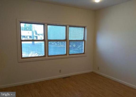 empty room with hardwood / wood-style flooring