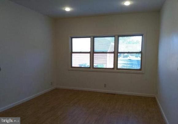 empty room with a healthy amount of sunlight and hardwood / wood-style flooring