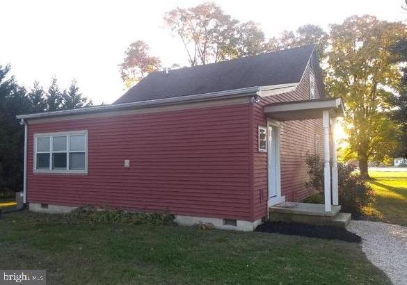 view of side of home with a yard