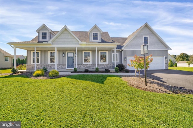 view of front of house featuring a garage, a porch, and a front lawn