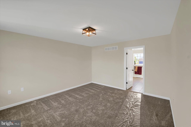 carpeted empty room with visible vents and baseboards