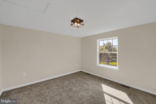 carpeted empty room featuring baseboards and visible vents