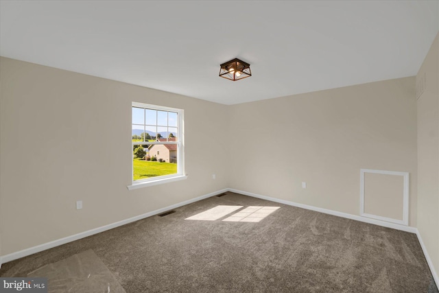 unfurnished room featuring carpet, baseboards, and visible vents