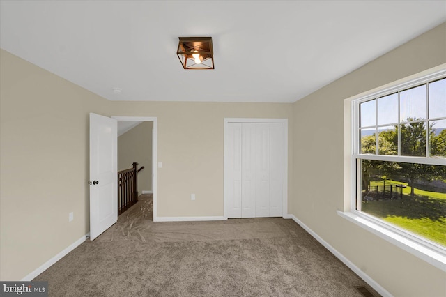 unfurnished bedroom featuring a closet, visible vents, baseboards, and carpet