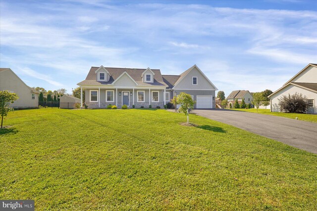 cape cod-style house featuring a garage and a front yard