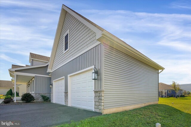 view of side of property with a lawn and a garage