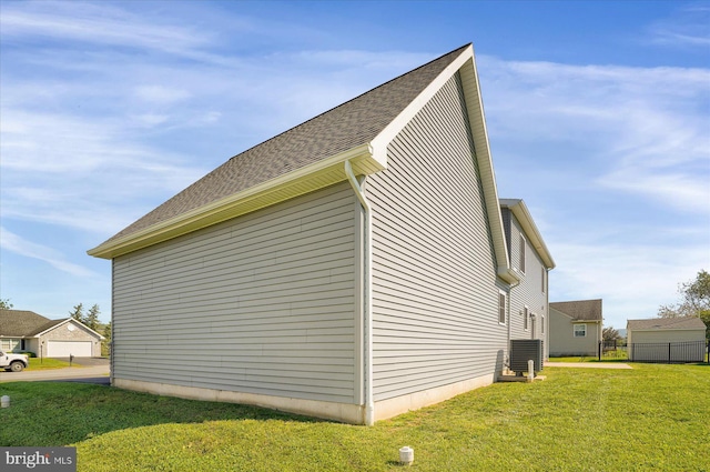 view of side of home featuring cooling unit and a yard