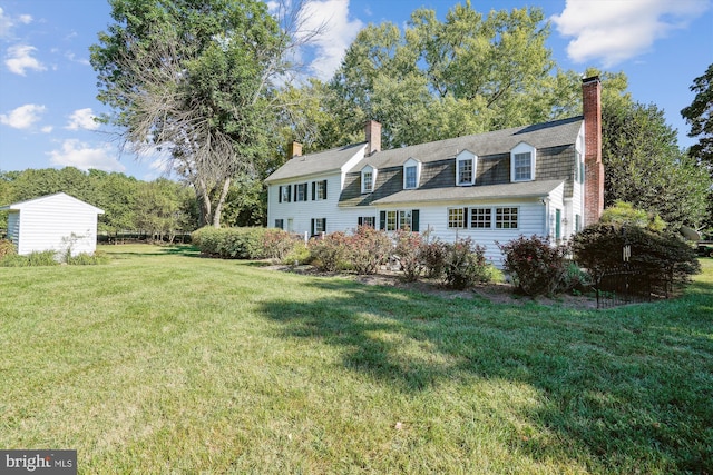 cape cod house featuring a front yard