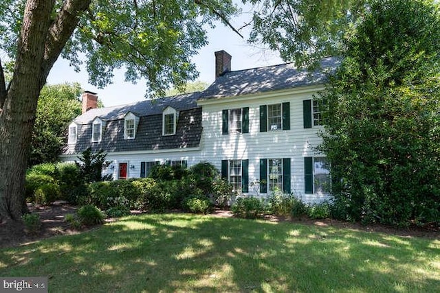 colonial-style house featuring a front lawn