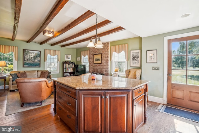 kitchen with a healthy amount of sunlight, hanging light fixtures, and hardwood / wood-style floors