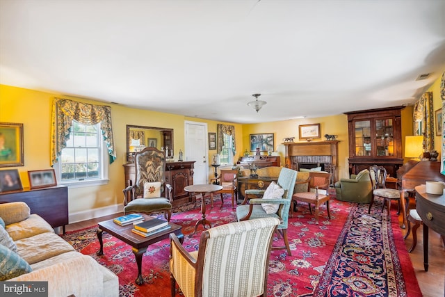 living room with wood-type flooring and a brick fireplace