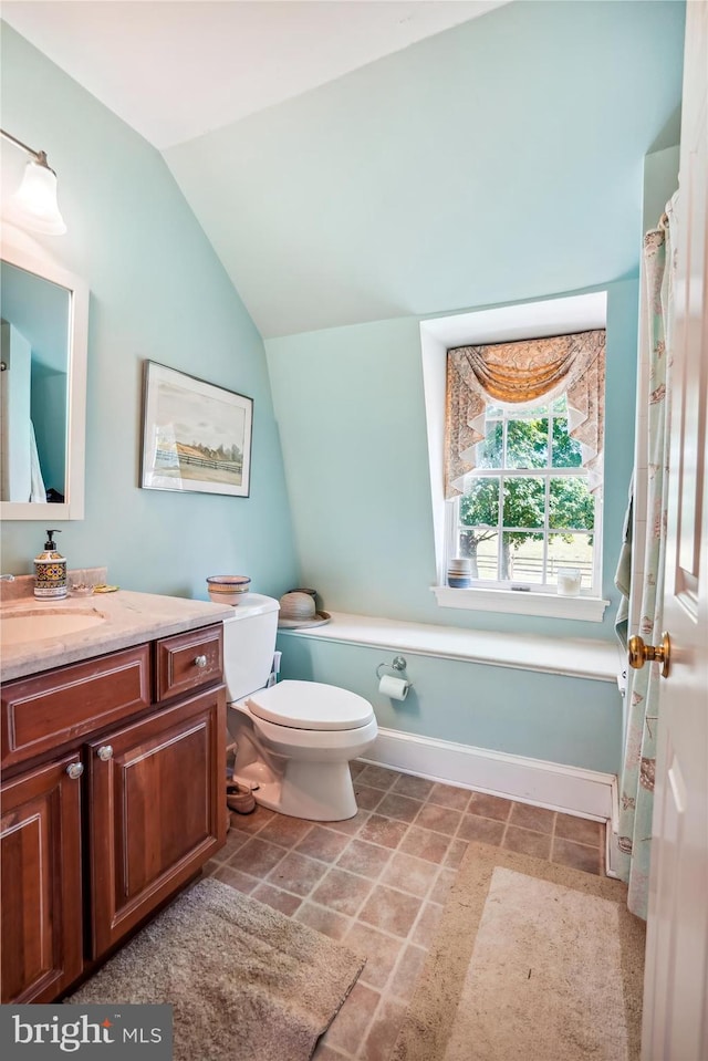 bathroom with vaulted ceiling, vanity, and toilet